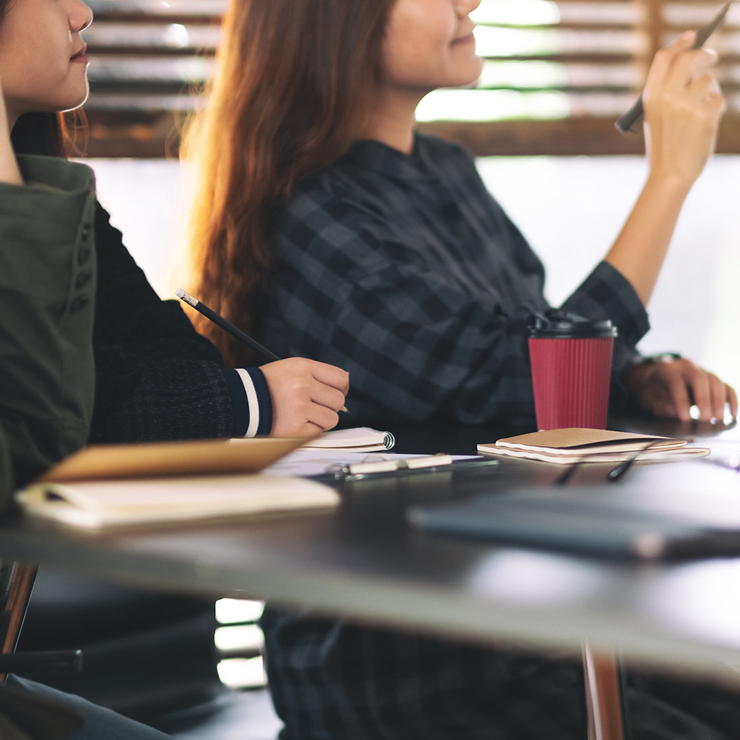 Businesspeople looking and discussing ideas over a board in office